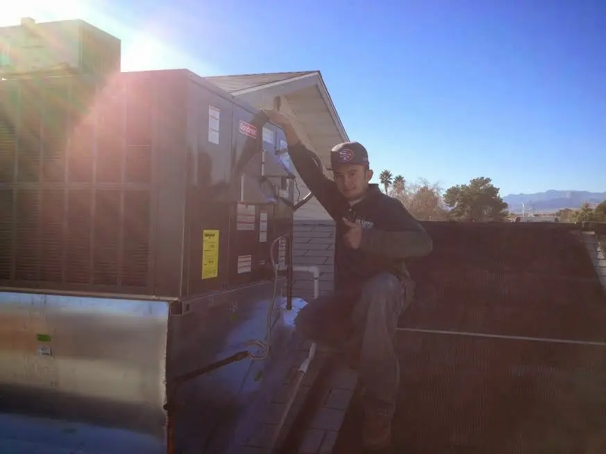 HVAC technician performing Boiler Repair on a rooftop unit in Hampton